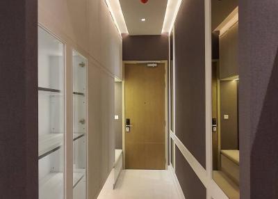 Modern corridor with LED lighting and glossy floor tiles leading to a wooden door