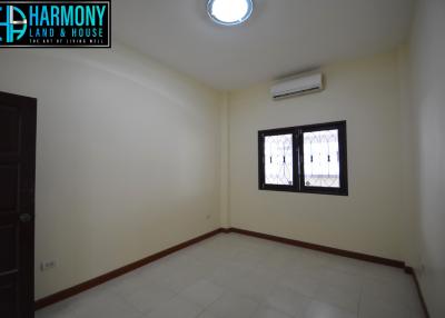 Spacious empty bedroom with tiled floors and air conditioning unit