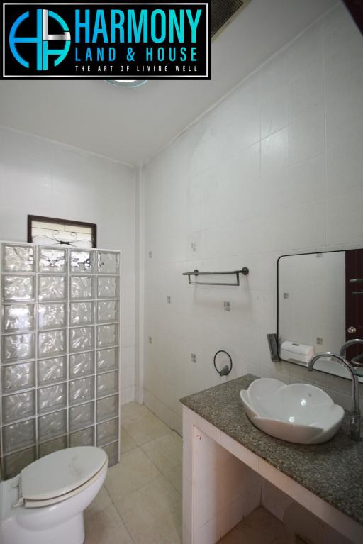 Modern bathroom interior with glass partition, white fixtures, and granite countertop