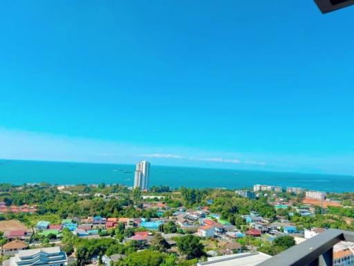 Spectacular coastal view from a high-rise balcony overlooking the sea and surrounding community