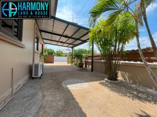 Spacious driveway with covered carport and tropical landscaping