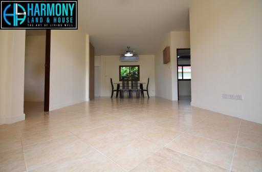 Spacious living room with tiled flooring and dining area in view