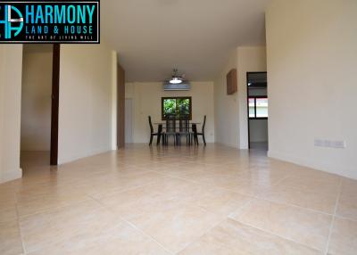 Spacious living room with tiled flooring and dining area in view