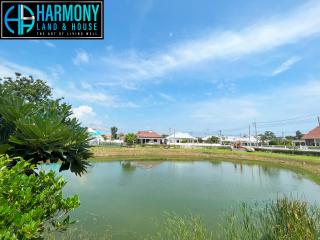Tranquil residential area with a scenic pond and clear blue skies