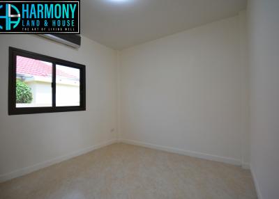 Spacious empty bedroom with a large window and air conditioning unit