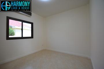 Spacious empty bedroom with a large window and air conditioning unit