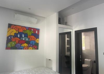 Modern bedroom with bold artwork and en-suite bathroom
