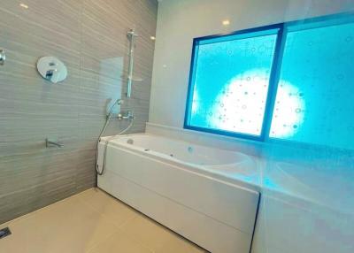 Modern bathroom with spa bathtub and large frosted glass window