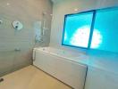Modern bathroom with spa bathtub and large frosted glass window