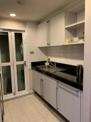 Compact modern kitchen with white cabinetry and black countertop