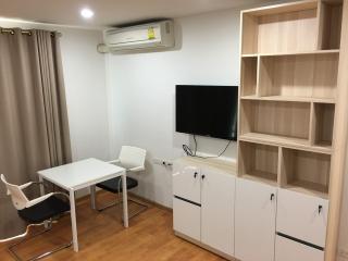 Cozy bedroom with modern furniture and wall-mounted TV