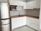 Modern white kitchen with stainless steel appliances