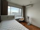 Spacious bedroom with large window and city view