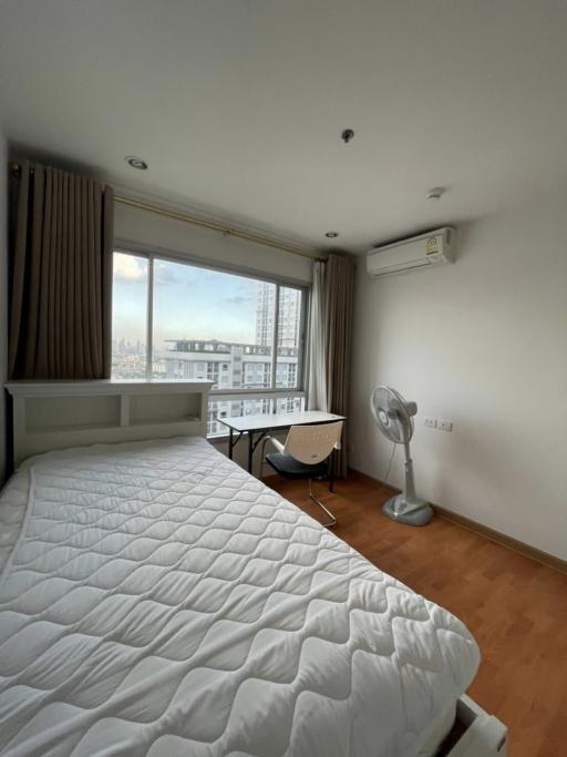 Spacious bedroom with large window and city view