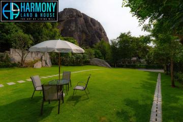 Spacious garden area with lawn chairs and a large stone backdrop