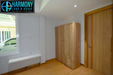 Spacious Bedroom with Wooden Wardrobe and Natural Light