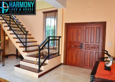 Elegant interior view with a wooden staircase and entrance door