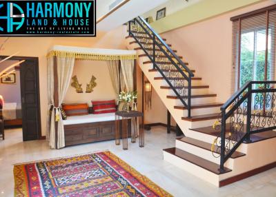 Elegant living room interior with staircase and colorful rug