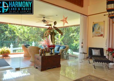 Spacious and well-lit living room with tropical scenery view