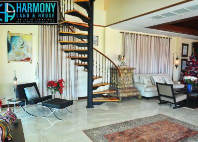 Spacious living room with a spiral staircase and festive decorations