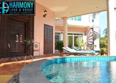 Cozy pool area with lounging chairs and a view of the house interior