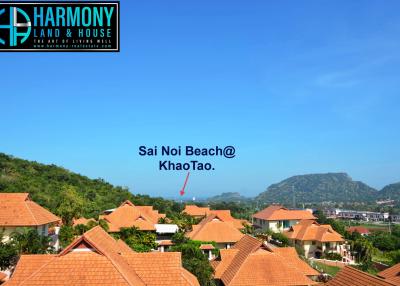 Panoramic view of Sai Noi Beach at Khao Tao with surrounding houses and lush hills