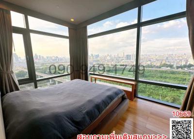 Modern bedroom with large windows offering a panoramic city view