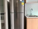 Modern kitchen with stainless steel refrigerator and wooden cabinets