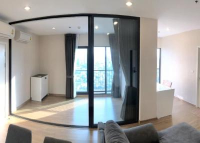 Spacious modern apartment interior with open plan kitchen, large windows, and abundant natural light