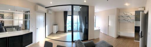 Spacious modern apartment interior with open plan kitchen, large windows, and abundant natural light