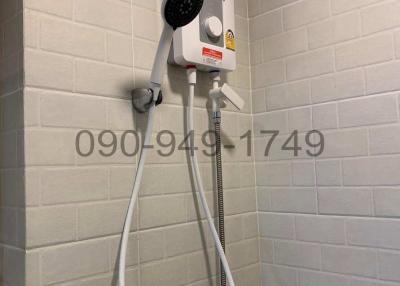 Electric water heater with shower head in bathroom