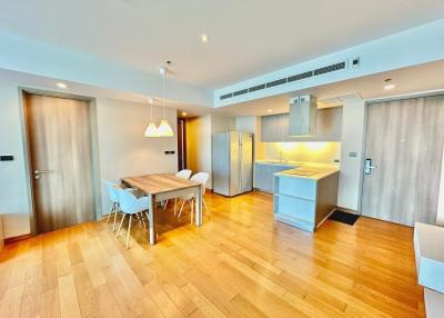 Modern open-plan kitchen with dining area and wood flooring in an apartment