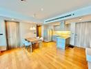 Modern open-plan kitchen with dining area and wood flooring in an apartment