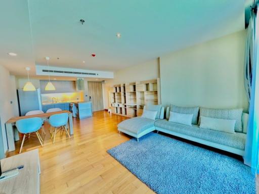 Modern living room connected to an open plan kitchen with bright lighting and contemporary furniture