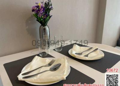 Elegant dining table set up with silverware and a flower vase