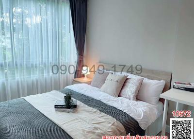 Modern and well-lit bedroom with large bed and sheer curtains