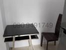 Small workspace area with a modern black table and one chair