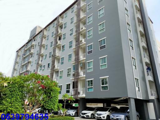 Exterior view of a modern residential apartment building with parked cars