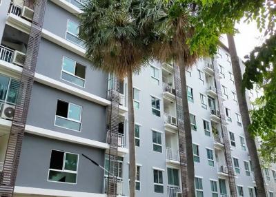 Exterior view of a modern apartment building with lush landscaping