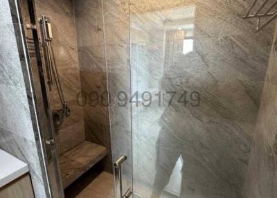 Modern bathroom with glass shower enclosure and grey tiles