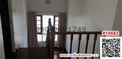 Spacious upper-level hallway with wooden banister and large windows