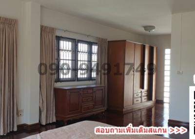 Spacious bedroom with large windows and wooden wardrobe