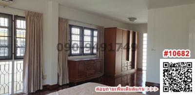 Spacious bedroom with large windows and wooden wardrobe