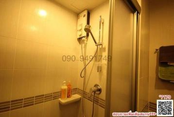 Compact bathroom with a wall-mounted water heater and glass shower enclosure