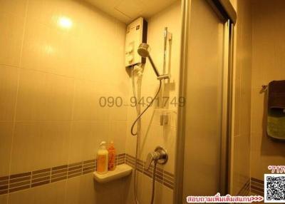 Compact bathroom with a wall-mounted water heater and glass shower enclosure