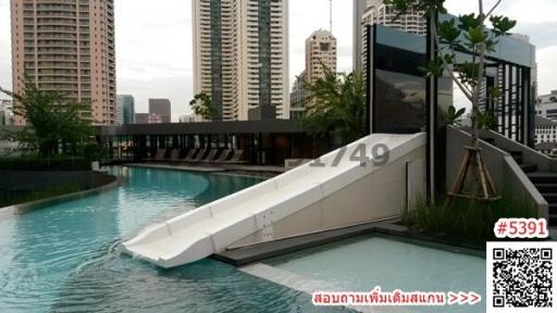 Modern outdoor swimming pool with cityscape view and a waterslide