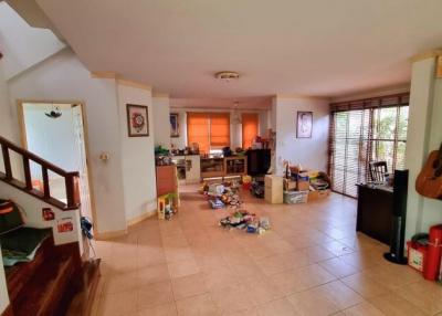 Spacious living area with kitchen in the background and staircase to the side