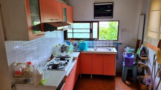 Bright kitchen with orange cabinetry and tiled backsplash