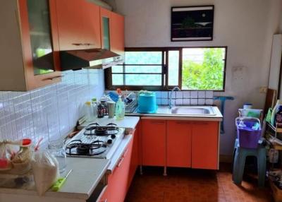 Bright kitchen with orange cabinetry and tiled backsplash