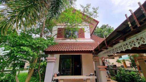 Traditional house with red roof surrounded by greenery